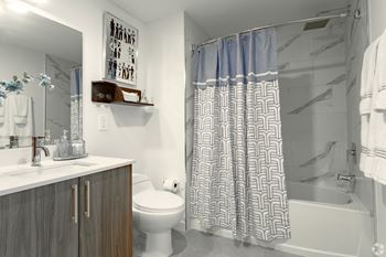 Modern bathroom with a toilet, sink, and shower in our model 2 bedroom apartment at Hollywood Heights on the Boulevard Luxury Apartments in Hollywood, FL